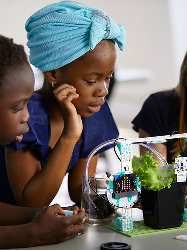 Three students examining Smart Farming Climate Action Kit with microcontroller and plant sensor | Forward Education