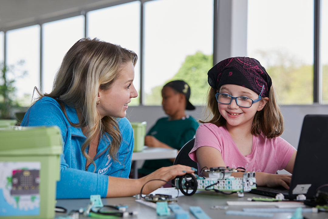 Female teacher helping student with Electric Vehicles Climate Action Kit project