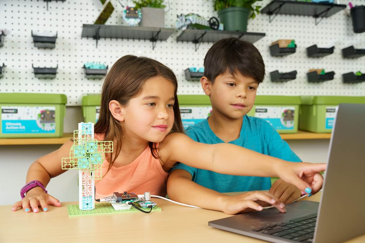 Two students working on the Wind Turbine Climate Action Kit project in front of a computer.