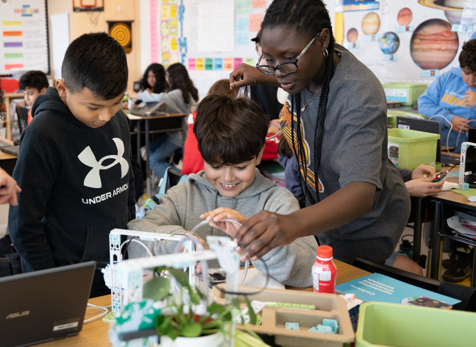 Teacher guiding students using white robotics kit with plant sensors in STEM lesson | Forward Education