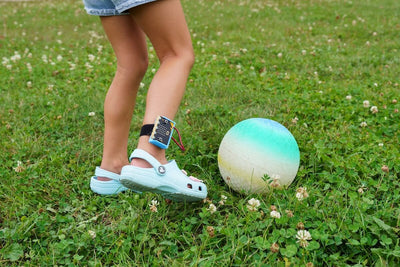 Student  wearing the micro:bit Charge device on their ankle, outside, about to kick a ball