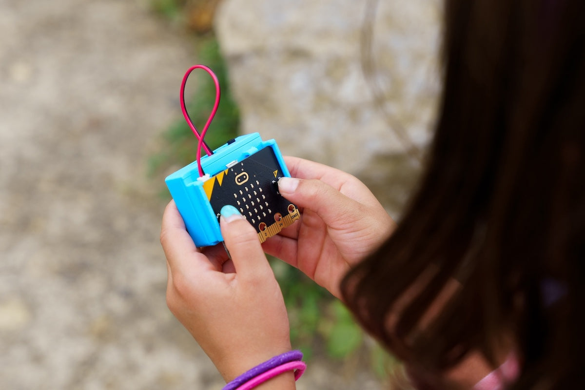 student holding the CHARGE for micro:bit device