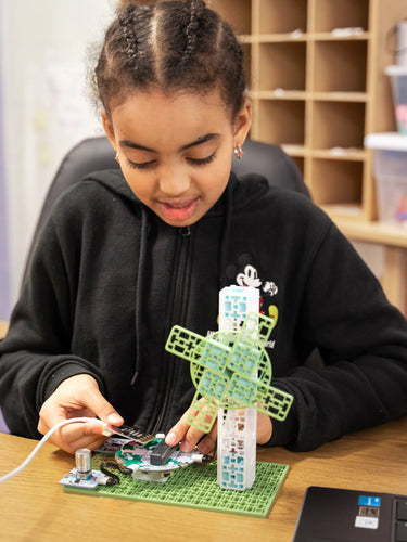 A girl connecting micro:bit to breakout board
