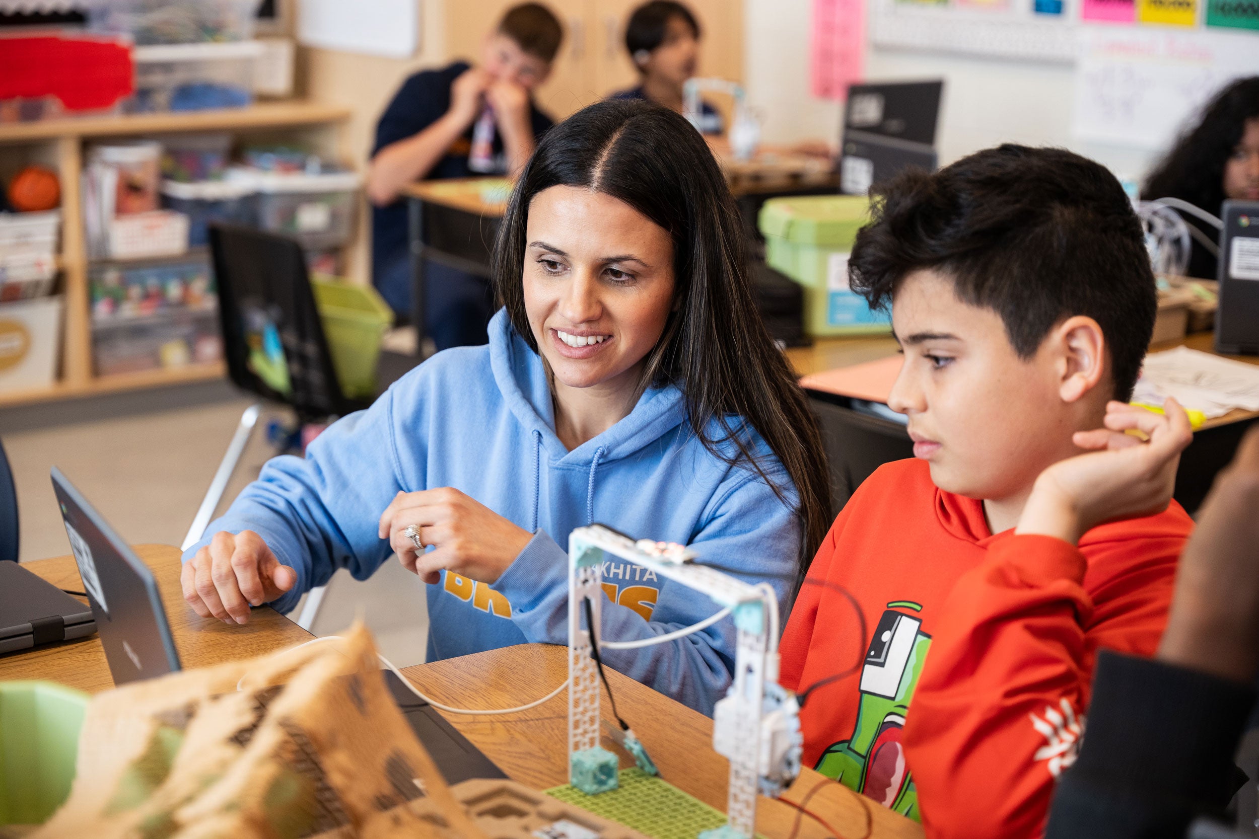 Teacher helping male student with Climate Action Kit project